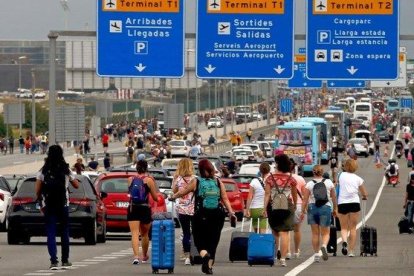 Varios viajeros cerca del Aeropuerto del Prat, afectados por las protestas convocadas por Tsunami Democratic tras la sentencia del juicio del ’procés’.-EFE (TONI ALBIR)