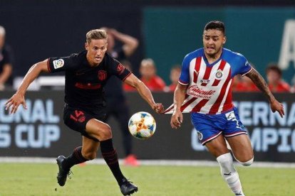 El jugador del Atlético Marcos Llorente (i) agarra al mexicano Vega en la jugada en la que fue expulsado.-EPA