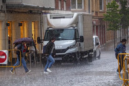 Gente corre para refugiarse de la tormenta de agua y granizo de este miércoles en Soria. MARIO TEJEDOR