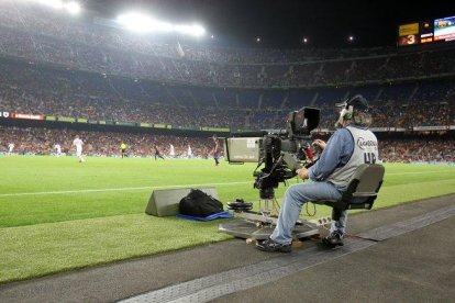 Un reportero gráfico grabando un partido de fútbol.-