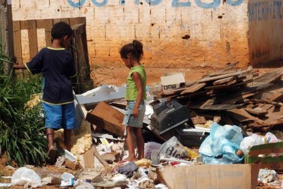 Dos niños buscan entre la basura en Brasilia, Brasil.-EFE/Archivo