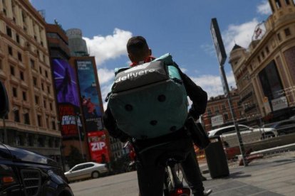 Un rider de Deliveroo realizando su reparto en su bicicleta.-SUSANA VERA (REUTERS)