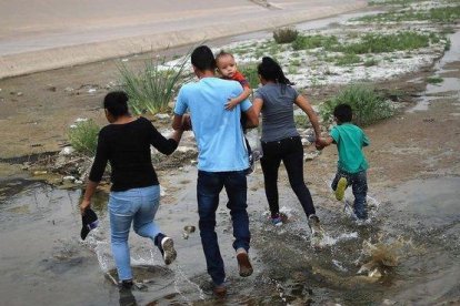 Una familia de inmigrantes cruzan de manera ilegal la frontera entre México y los EEUU. / MARIO TAMA (AFP)-AFP / MARIO TAMA