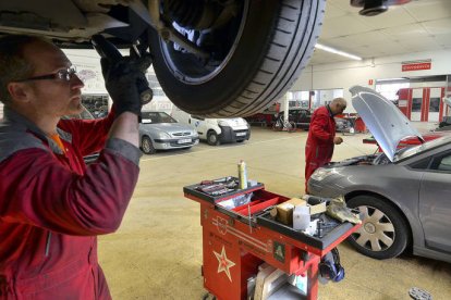 Un operario arreglando un vehículo en suspensión en el taller del concesionario Citroën Autopalacio, que se encuentra en la avenida de Valladolid. / ÁLVARO MARTÍNEZ-