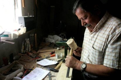 El artista Félix Morán en el taller donde realiza maquetas de aperos de labranza en la localidad leonesa de Fresno de la Vega. ICAL-