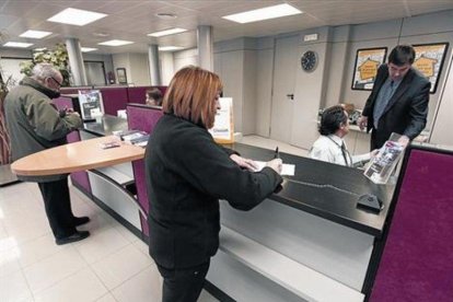 Una clienta realiza una gestión en una oficina bancaria en Tona (Osona).-JOSEP GARCIA