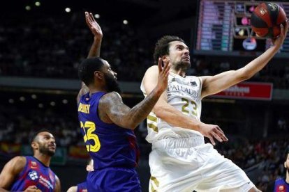 Serbgio Llull entra a canasta defendido por Malcolm Delamey.-EFE / EMILIO NARANJO