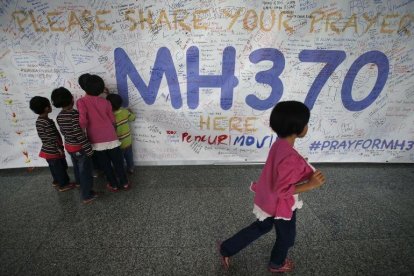 Un grupo de niños escribiendo mensajes esperanzadores para los familiares de las personas que desaparecieron en el vuelo MH370, de la compañía Malasya Airlines, en mayo del 2014.-AP / WONG MAYE-E (AP)