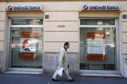 Un hombre pasa frente a una oficina de Unicredit en Milán.-DARIO PIGNATELLI / REUTERS