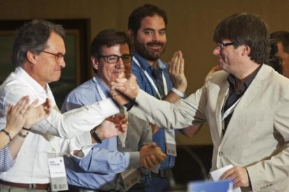 El presidente de la Generalitat, Carles Puigdemont (derecha) saluda al 'expresident' Artur Mas en el acto de Lloret de Mar.-Robin Townsend