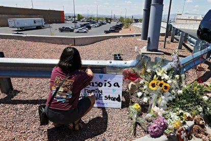 Una mujer coloca flores cerca del lugar del ataque en El paso.-EFE / LARRY W. SMITH