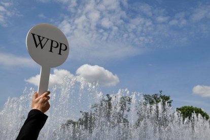 Un guía de la firma WPP en Londres atrae a los congregados con el logo de la compañía.-X90004