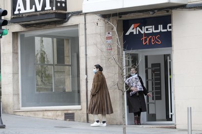 Personas junto a un local comercial recientemente cerrado. LUIS ÁNGEL TEJEDOR