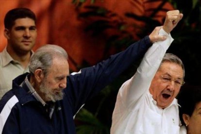 Fidel levanta el brazo de Raúl, en abril del 2011.-AFP / REUTERS / AP