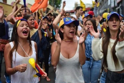 Varias jóvenes gritan consignas contra el presidente Maduro, en Los Teques (Estado de Miranda, Venezuela).-AFP / RONALDO SCHEMIDT