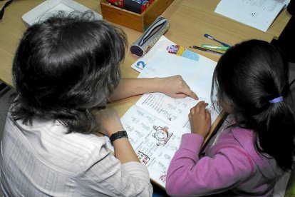Una especialista presta apoyo escolar a una alumna, en una fotografía de archivo.-E. M.