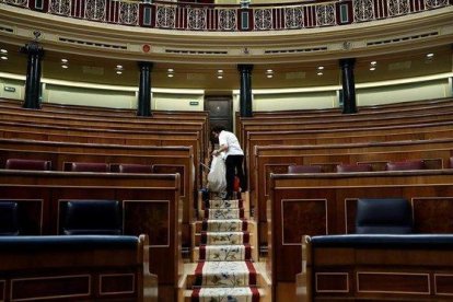 Labores de limpieza en el hemiciclo del Congreso de los Diputados, tras quedarse vacío el pasado 28 de febrero.-EFE / CHEMA MOYA