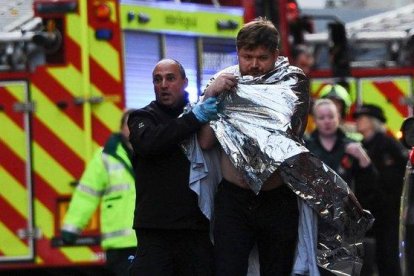 La policía asiste a un hombre herido en el ataque en el Puente de Londres, este viernes.-AFP