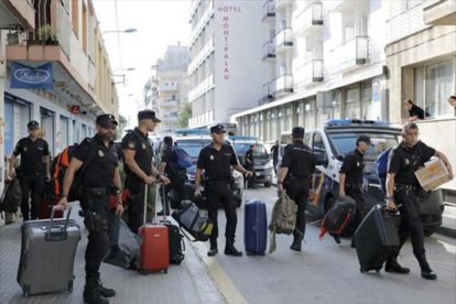 Policías nacionales cuando abandonaron el hotel de Pineda de mar en el que se alojaban tras el 1-O.-/ EFE / ANDREU DALMAU