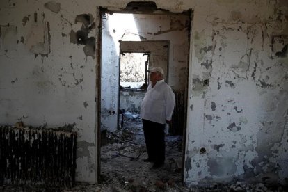 Un hombre en su casa quemada de Mati. /-REUTERS / COSTAS BALTAS