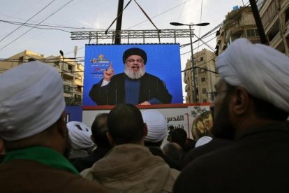 Seguidores de Hizbulá escuchan a su líder que aparece en una pantalla gigante en una manifestación en Beirut.-/ BILAL HUSSEIN / AP