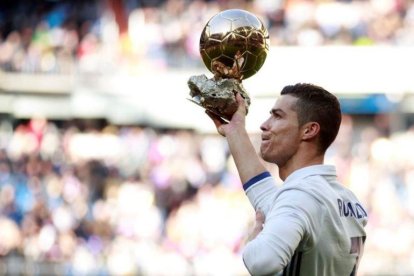 Cristiano Ronaldo ofrece el Balón de Oro al público del Bernabéu antes del encuentro ante el Granada.-REUTERS / STRINGER