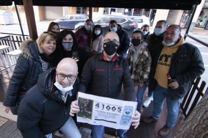 José Félix Aramayo sostiene una copia del número premiado entre algunos agraciados y amigos. GONZALO MONTESEGURO