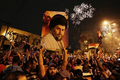 Un seguidor de Moqtada al Sadr sostiene una foto del clérigo en una concentración en la plaza Tahrir de Bagdad para celebrar el resultado electoral.-/ AP / HADI MIZBAN