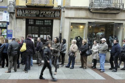 Cola para adquirir décimos para el sorteo de Navidad en la administración número uno, ayer en el Collado. / ÁLVARO MARTÍNEZ-