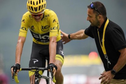 Un empleado del Tour ayuda a Chris Froome, tras cruzar la meta de Peyragudes.-AFP / LIONEL BONAVENTURE