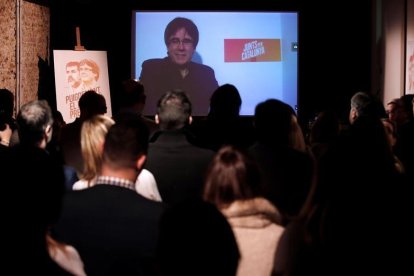 El expresidente de la Generalitat, Carles Puigdemont, conversa por videoconferencia con candidatos y simpatizantes durante la inauguración de la sede de campaña de Junts per Catalunya.-EFE