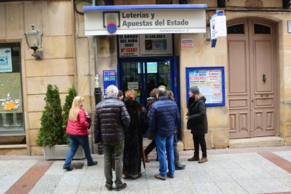 Varias personas hacen cola en el acceso a una administración.-ÁLVARO MARTÍNEZ