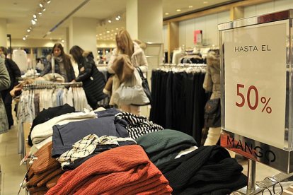 Varias personas observan el género en un comercio textil en Soria durante la mañana de ayer.-VALENTÍN GUISANDE