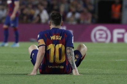 Leo Messi yace en el campo tras notar molestias en el aductor izquierdo en el partido ante el Villarreal.-AP / JOAN MONFORT