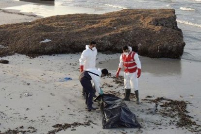 Miembros de la Media Luna Roja libia retiran el cadáver de un inmigrante fallecido en su intento de llegar a territorio europeo.-EFE