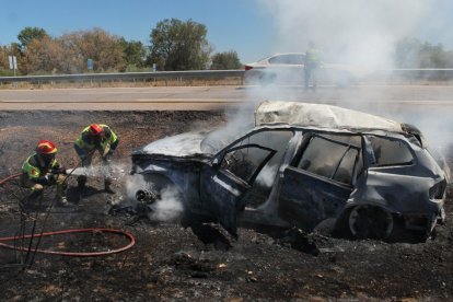 Los bomberos sofocan las llamas con el vehículo completamente calcinado. VICENTE-ICAL