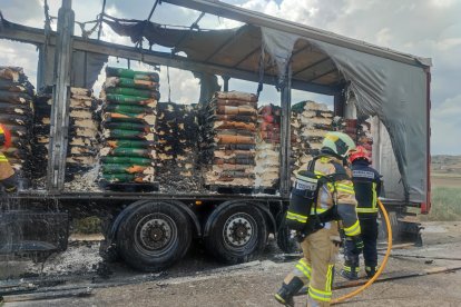 Los bomberos trabajan en el remolque incendiado.