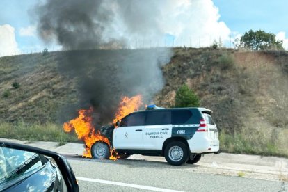 Vehículo en llamas de la Guardia Civil de Tráfico.