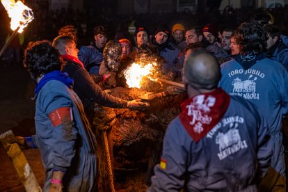 Miembros de la Asociación del Toro Jubilo cumpliendo con la tradición de embarrar al toro y prender fuego a las bolas de las astas.