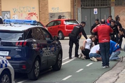 Unos jóvenes atienden al aficionado donostiarra en presencia de la Policía.