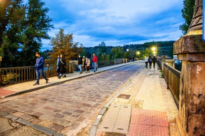 Varias personas transitan por el puente de piedra de Soria.