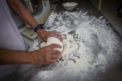 Un panadero amasando pan.