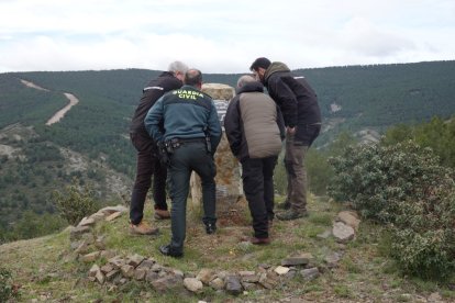 La Guardia Civil observa el monolito, con la placa arrancada.