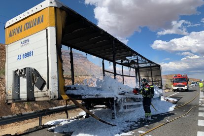 Los bomberos sofocan un incendio en un tráiler cargado con material de construcción.