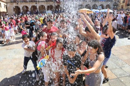 Varios jóvenes se llevan un buen remojón en la plaza Mayor.