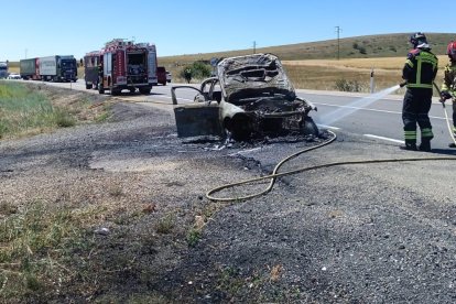 Intervención de los bomberos en el incendio de un coche.