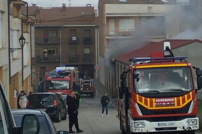 Los bomberos intervienen en la cochera incendiada, de la que sale bastante humo.