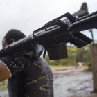 Un miembro de las FARC entrega un fusil de asalto.-AFP