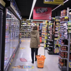 Una clienta deambula entre los estantes llenos de productos de un supermercado .-EL PERIÓDICO