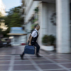 Un hombre entra dinero con una maleta en una sucursal bancaria de Atenas.-Foto: REUTERS / MARKO DJURICA
